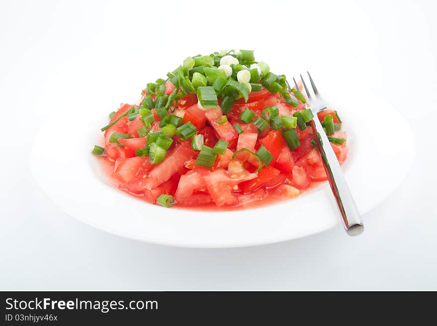 Tomato salad with spring onion on the white background