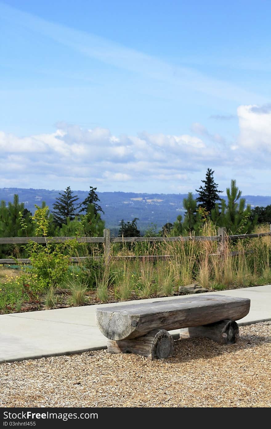 Long seat made out of an old weathered tree trunk overlooking a valley view in Oregon. Long seat made out of an old weathered tree trunk overlooking a valley view in Oregon.