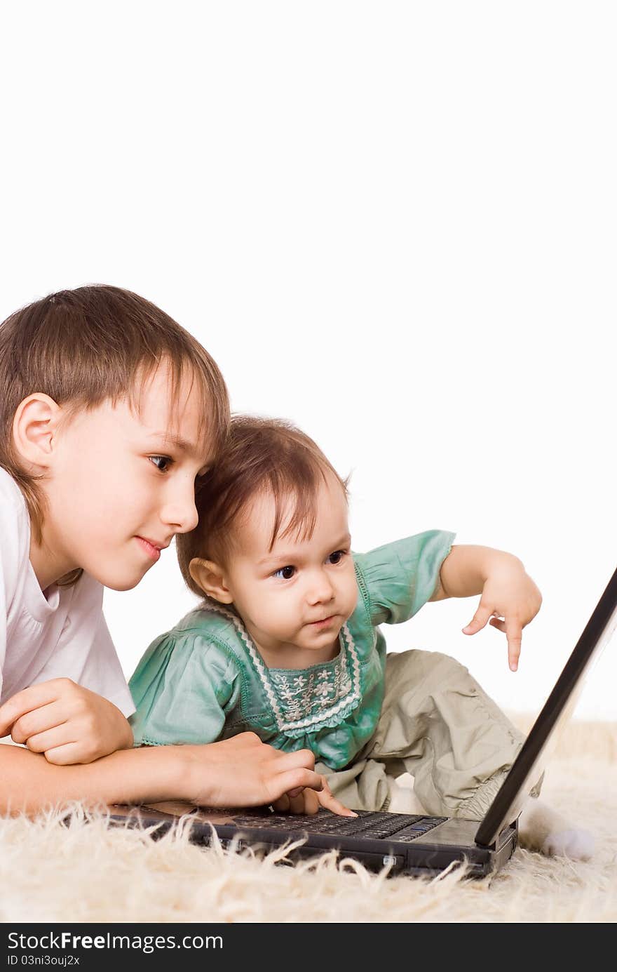 Cute kids with a laptop on carpet. Cute kids with a laptop on carpet