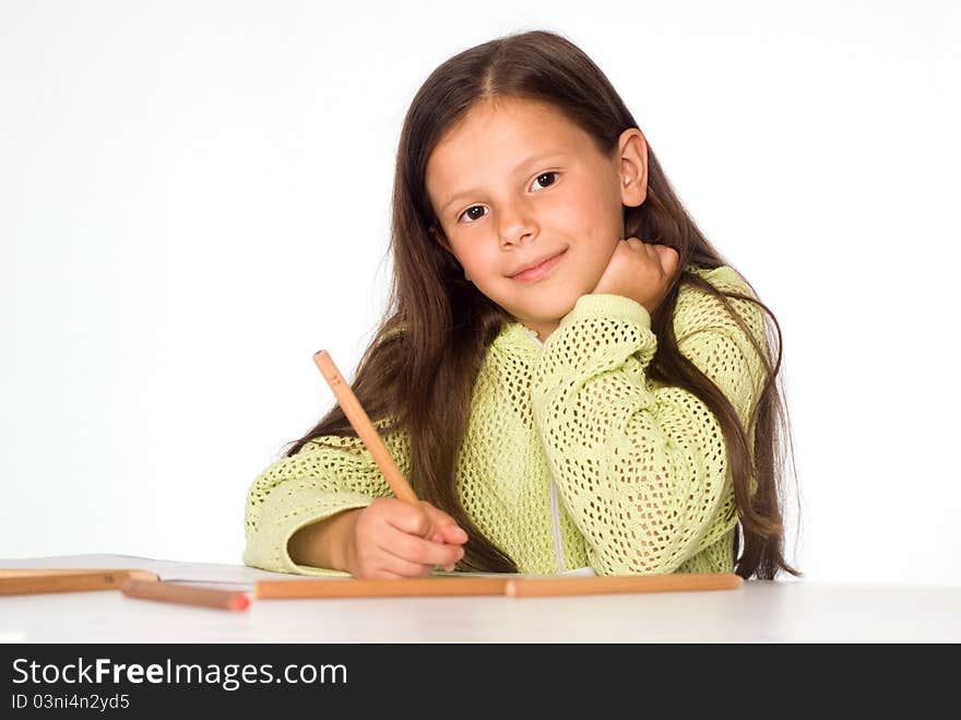 Nice little girl drawing at the table