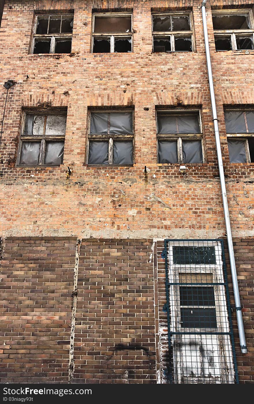 Angle shot of an abandoned industrial building with brick wall