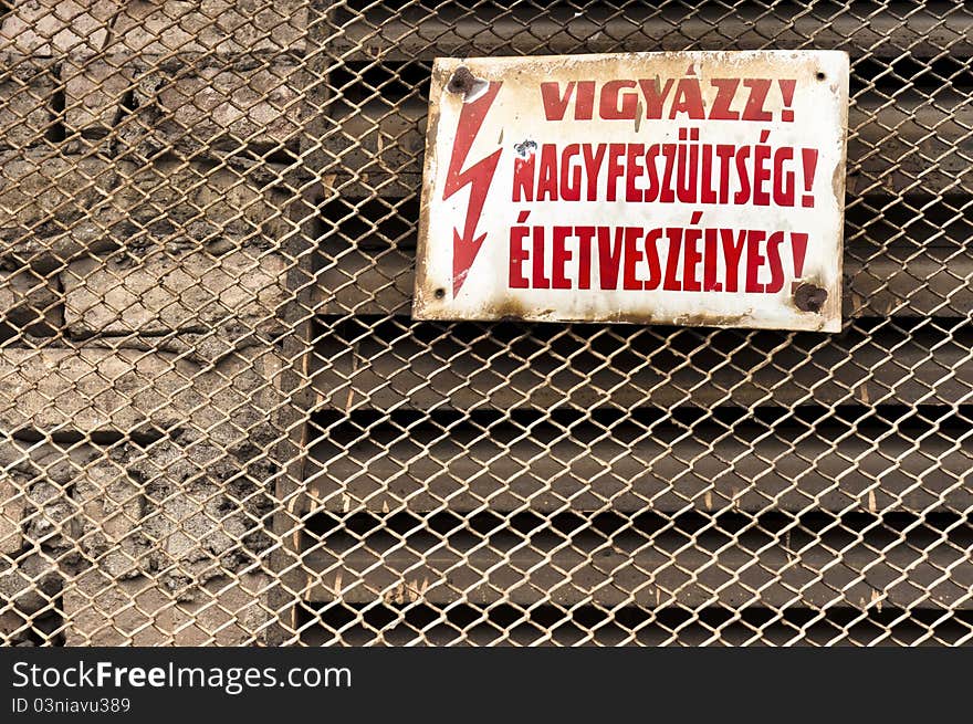 Danger! High voltage sign on metal fence