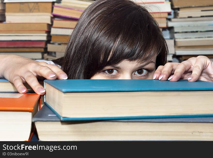 Young beautiful student girl behind books