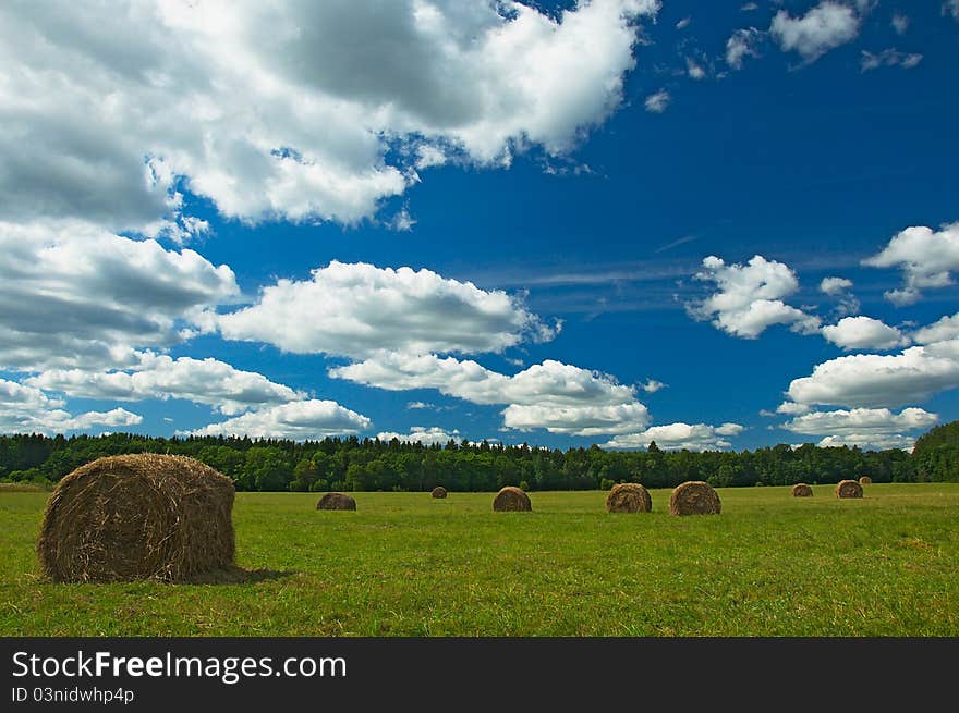 Green field with haystacks