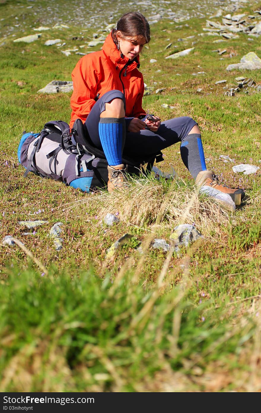 Young woman resting on her backpack during mountain hike. Young woman resting on her backpack during mountain hike