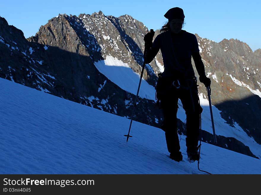 Silhouette of a climber walking across mountain glacier. Silhouette of a climber walking across mountain glacier