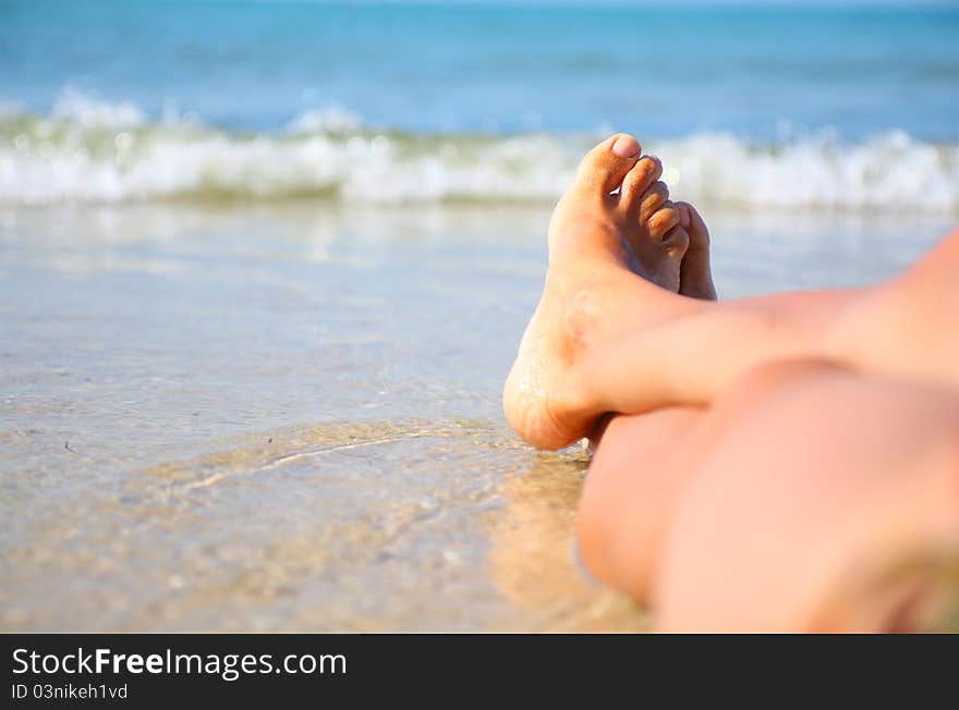 Wet female feet on the beach and sand. Wet female feet on the beach and sand