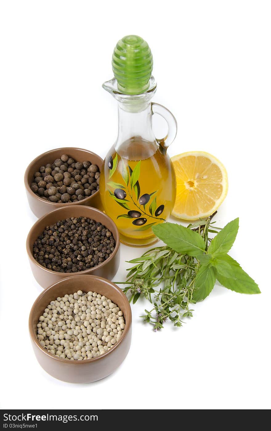 Oil in bottle and herbs on white background. Oil in bottle and herbs on white background