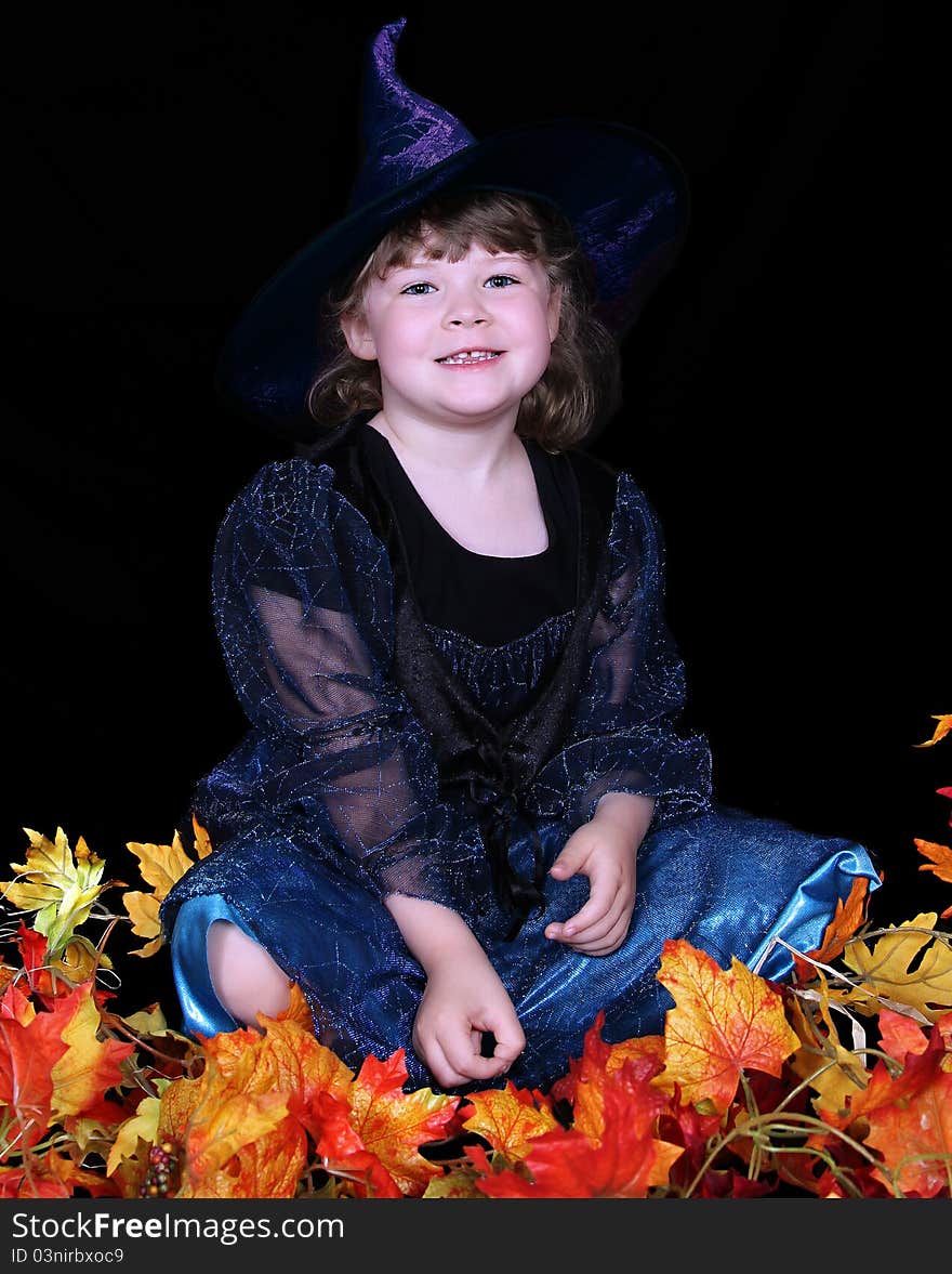 Adorable Little Girl In Witch Costume With Leaves