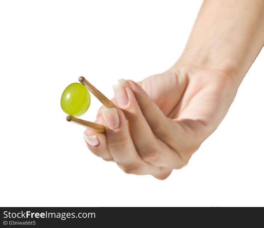Green grape held with Chinese sticks by a beautiful woman hand. Green grape held with Chinese sticks by a beautiful woman hand.