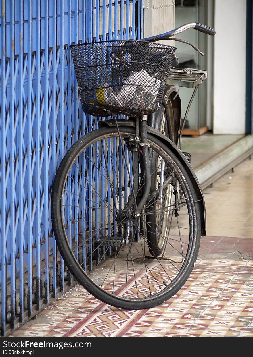 An old bicycle leaning against a shop front. An old bicycle leaning against a shop front