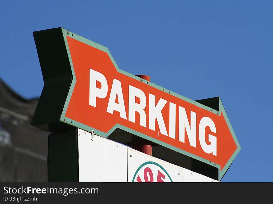 Parking sign with red arrow pointing out.