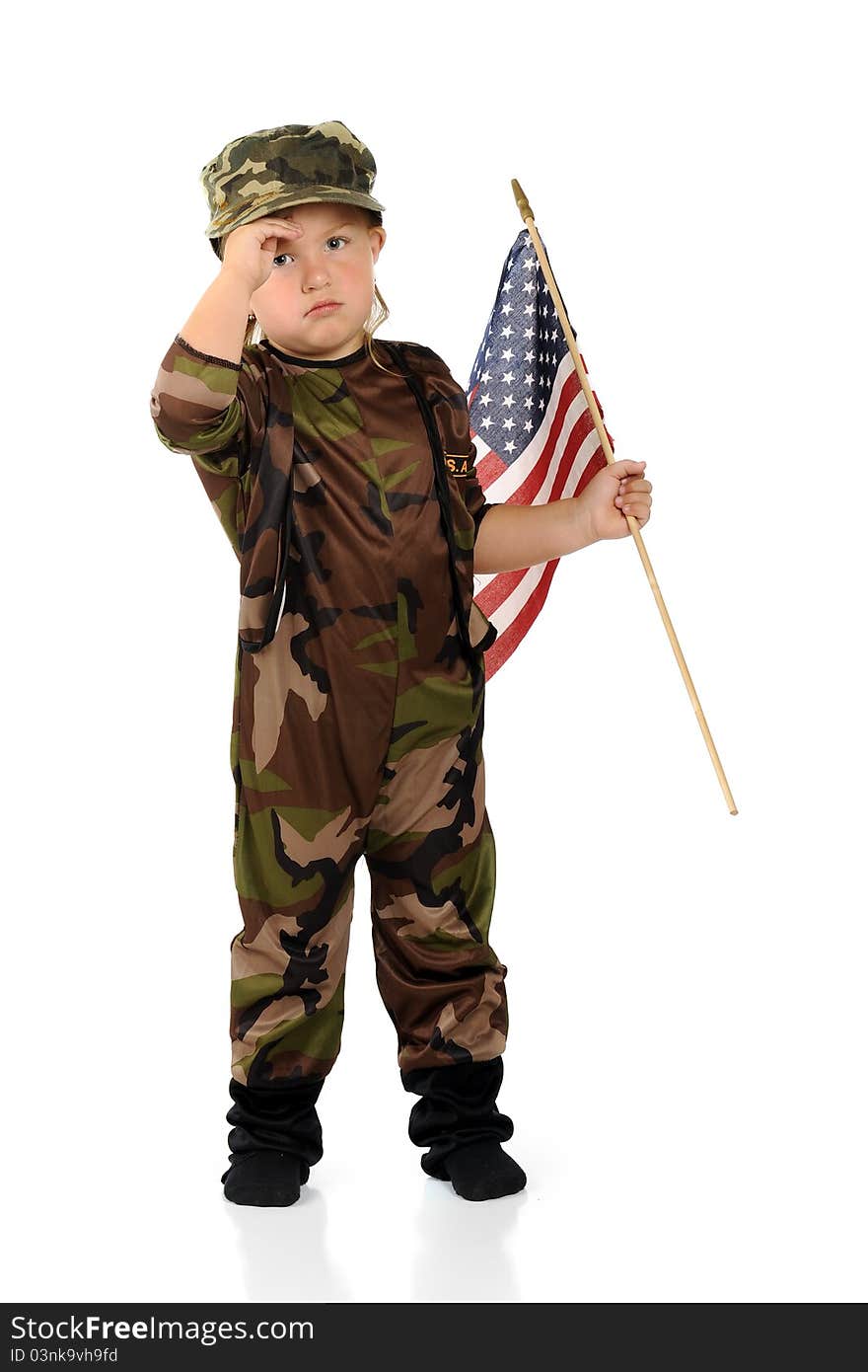 A pretty preschool soldier in army camouflage saluting as she carries an American flag. Isolated. A pretty preschool soldier in army camouflage saluting as she carries an American flag. Isolated.