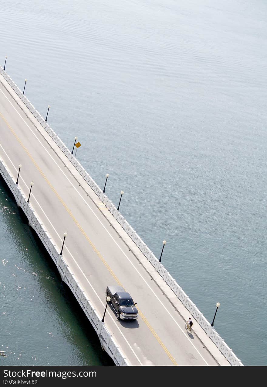 Bike and Truck on road bridge over water. Bike and Truck on road bridge over water