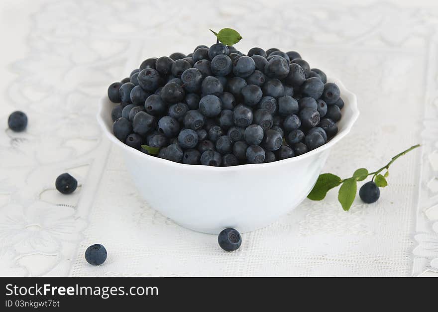 Bowl of bilberries on white background