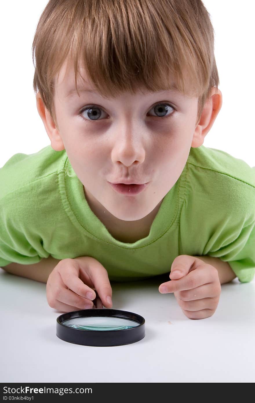 Boy with magnifying glass isolated on a white background