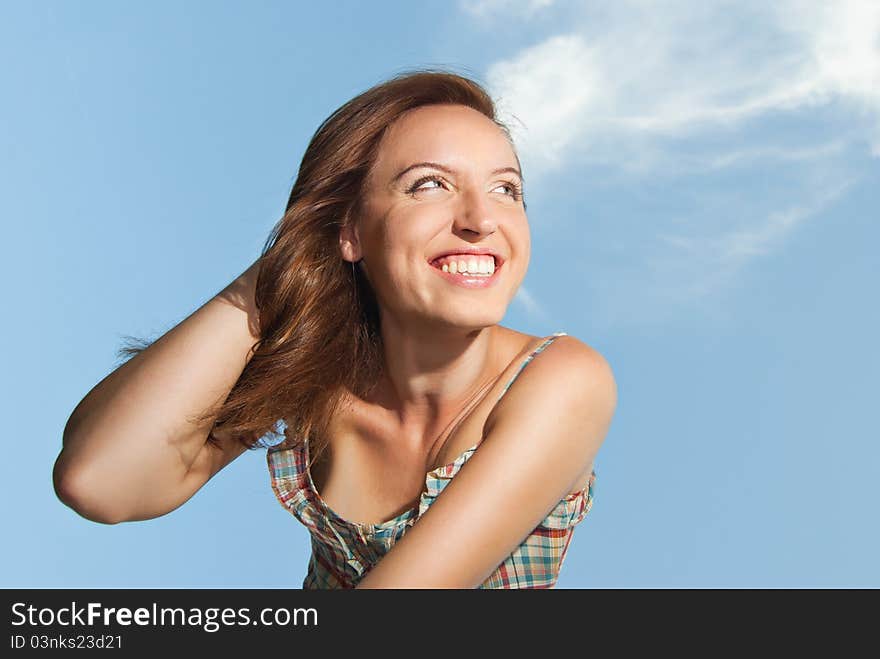 Beautiful Young Woman Smiling Against The Sky