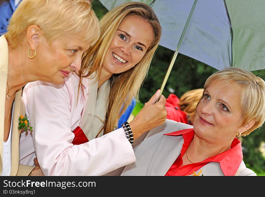 Three women at wedding during the rainy day.