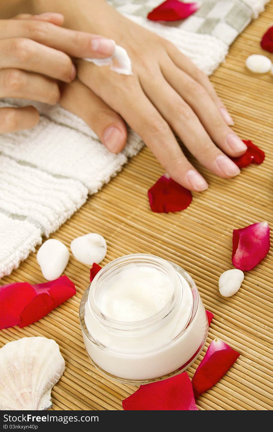 Close-up of girl lying on hand towel next to the cream, rose petals. Close-up of girl lying on hand towel next to the cream, rose petals