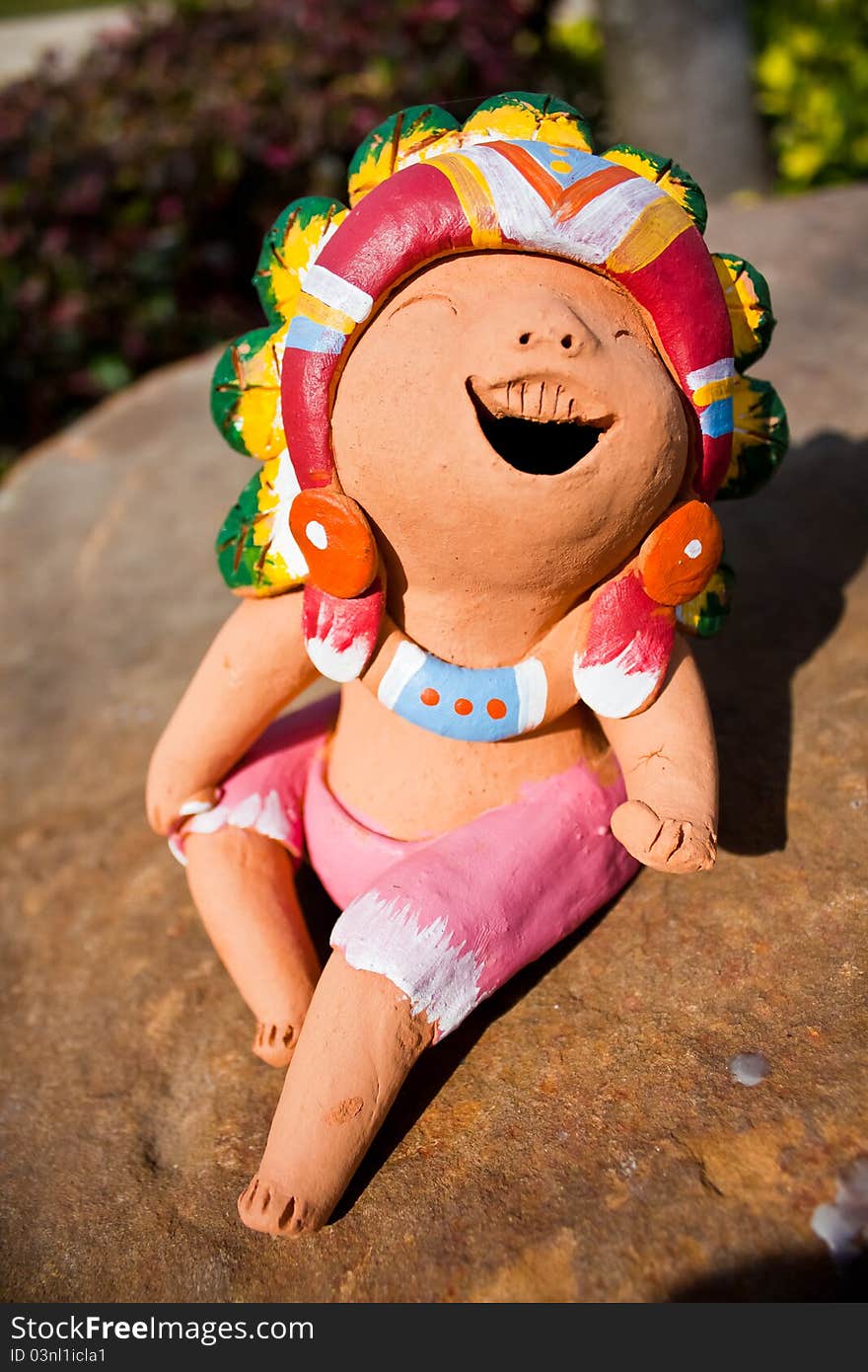 The Ceramic Laugh Doll sit on the Rock