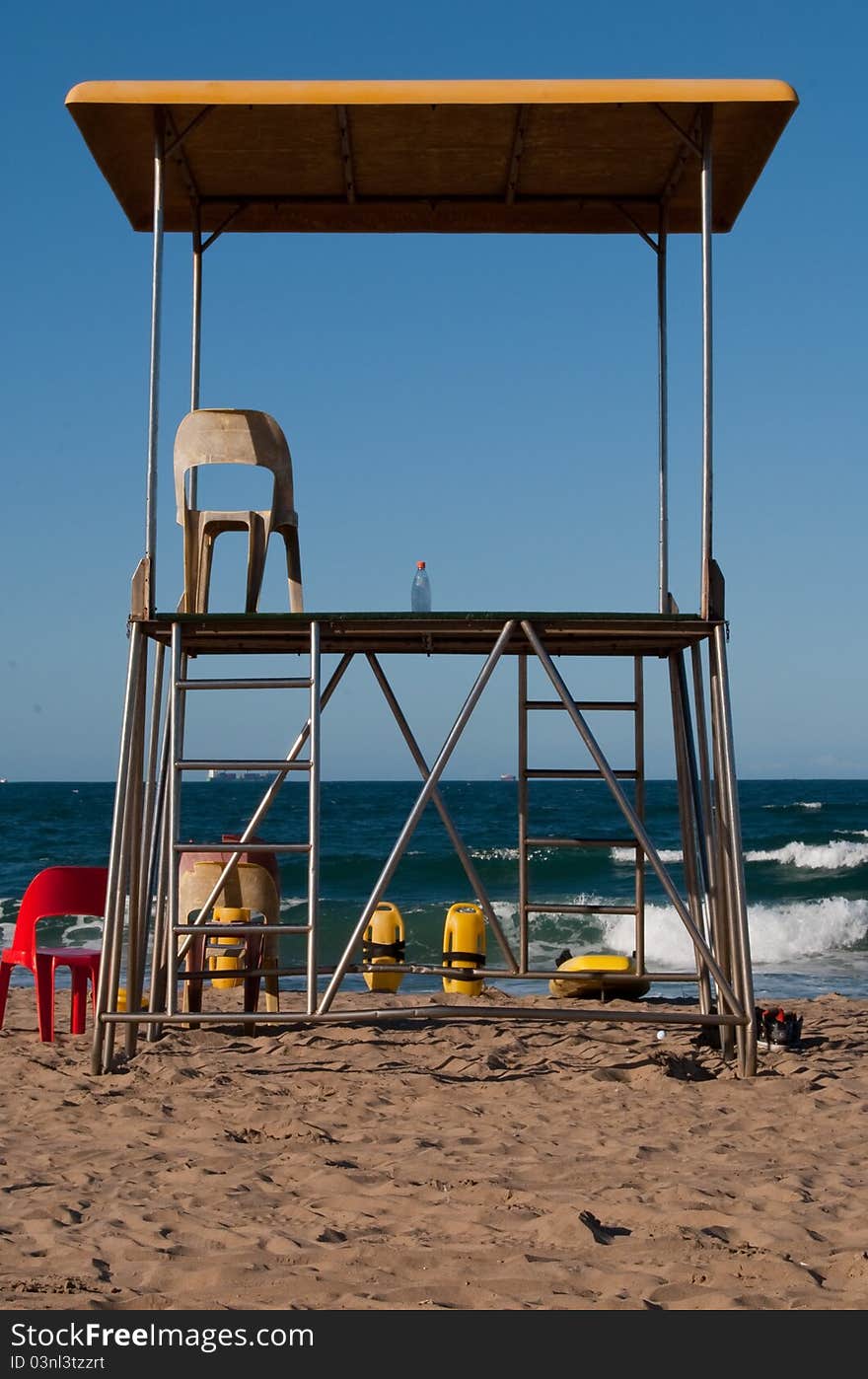 A life guard's outlook platform on North Beach, Durban, South Africa, with no life guard in sight. only his water bottle left on the platform. A sunny, cloudless day. A life guard's outlook platform on North Beach, Durban, South Africa, with no life guard in sight. only his water bottle left on the platform. A sunny, cloudless day.