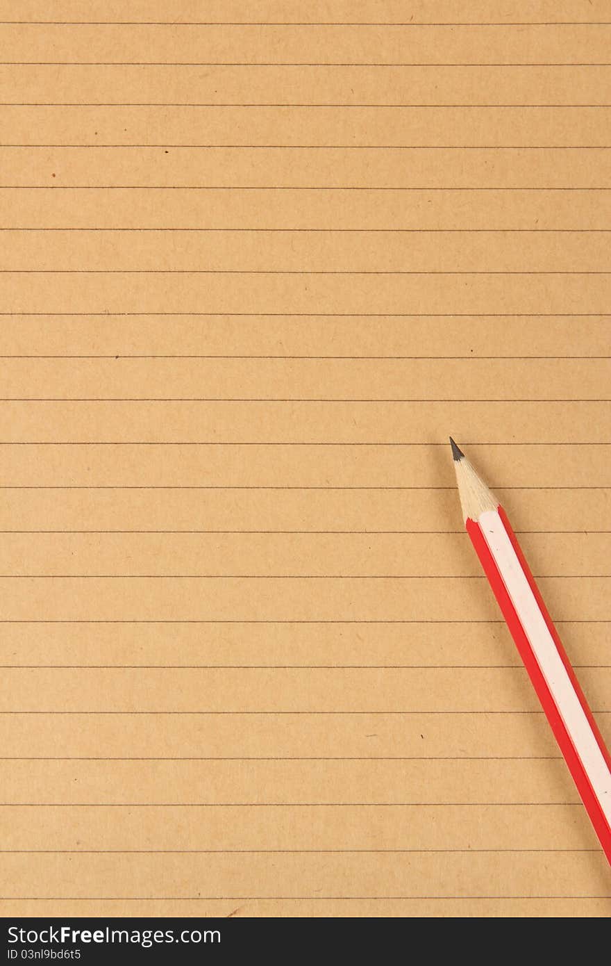 Brown writing paper background with a single pencil