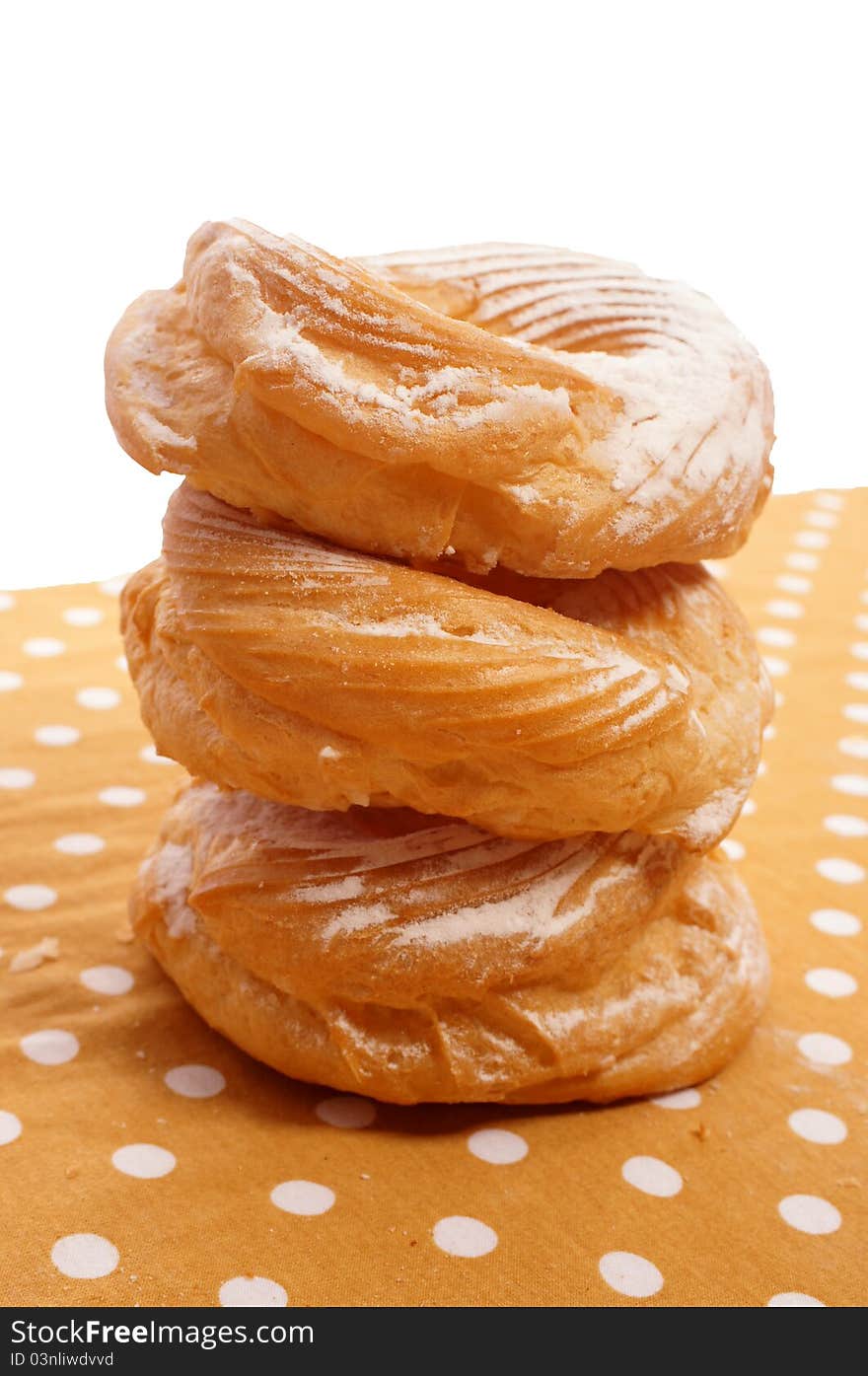 Three doughnuts with sugar on the tablecloth