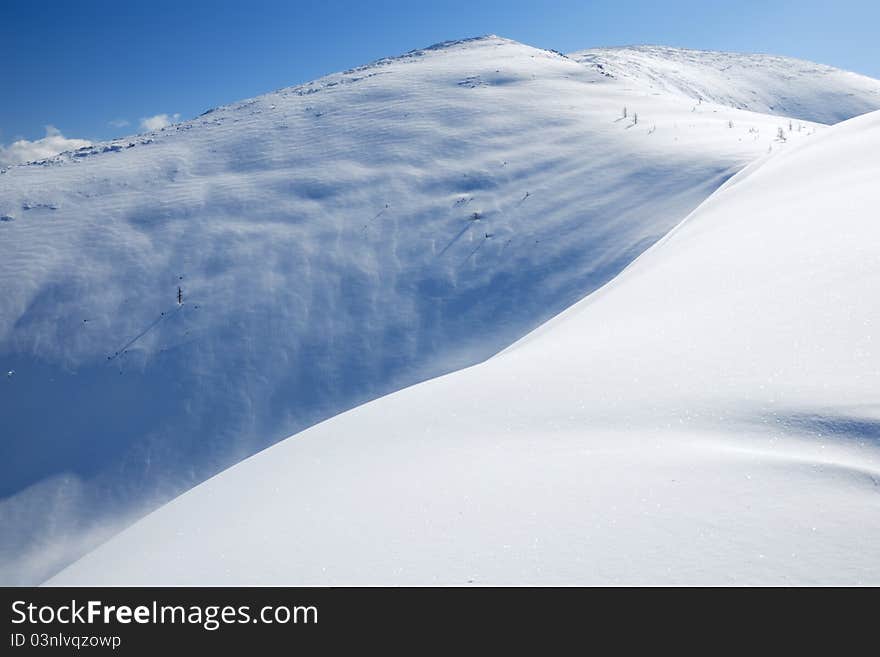 The snow slope in winter mountains. Freeride and backcountry snowboarding/skiing place. The snow slope in winter mountains. Freeride and backcountry snowboarding/skiing place