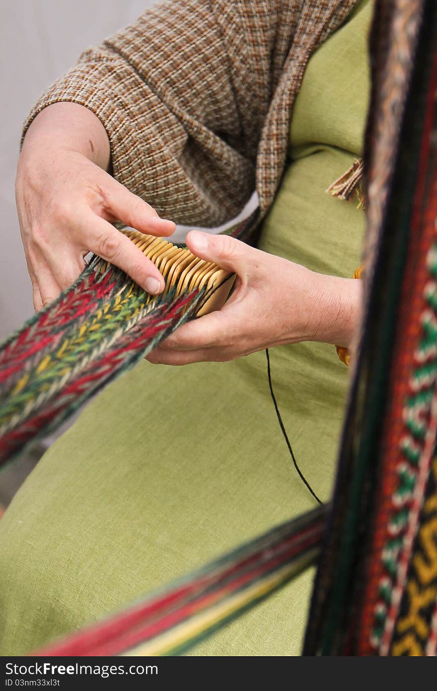 Woman crocheting pattern stripes with traditional tool