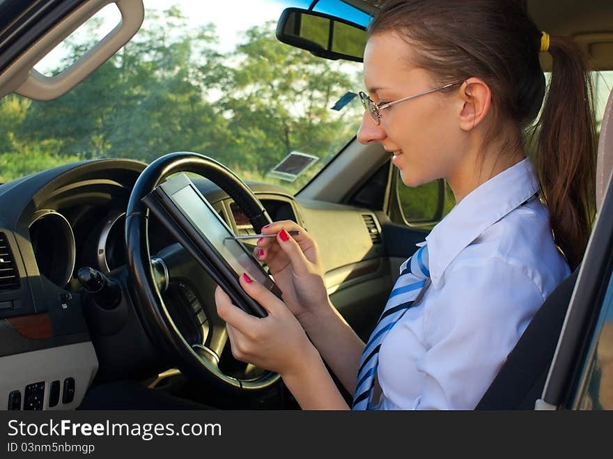 Young lady reads electronic book sitting in the car