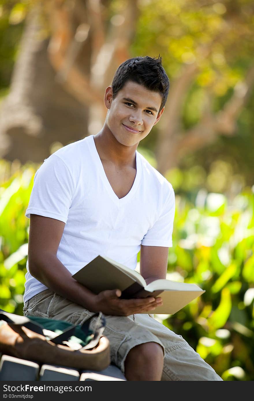 Student with backpack studying outside. Student with backpack studying outside