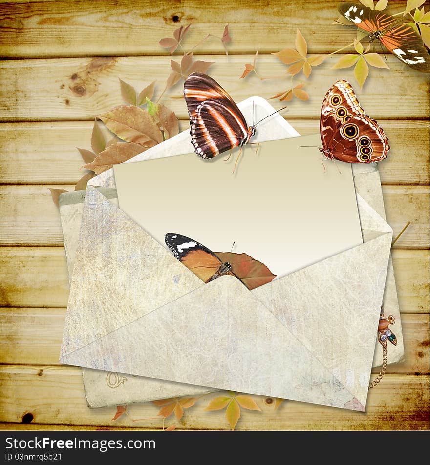 Wooden background with butterflies and envelope with space for text or photo