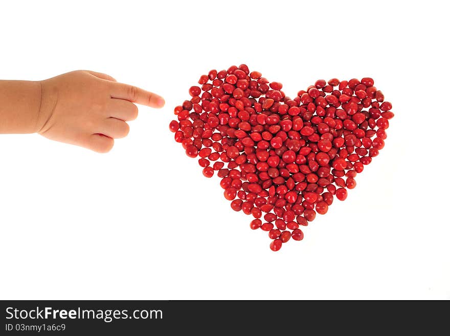 Child Finger Pointing To A Heart Shape Arranged With Red Love  Beans. Child Finger Pointing To A Heart Shape Arranged With Red Love  Beans