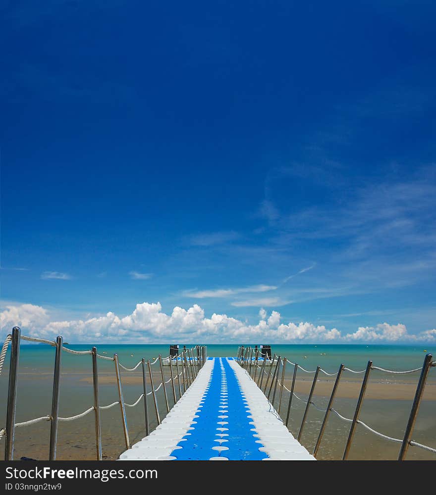 Perspective line of bridge to the sea on nice sky.