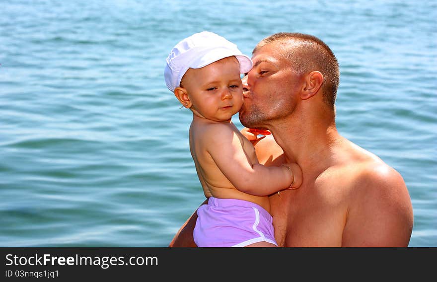 Father kissing his daughter during vacation in the sea (ocean)