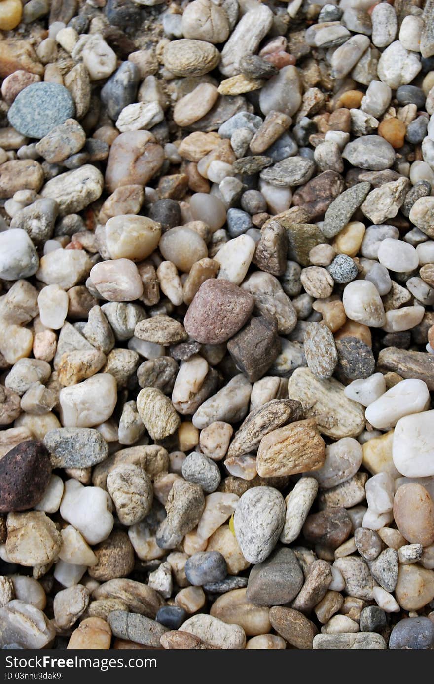 A close up view of smooth polished multicolored stones  washed ashore on the beach.