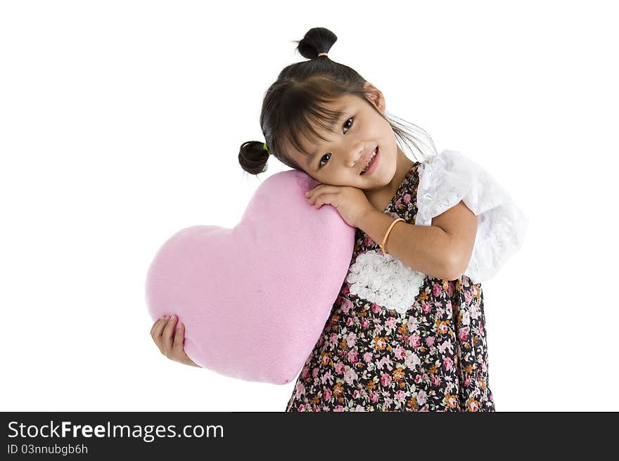 Pretty little girl with heart shaped pillow, isolated on white background