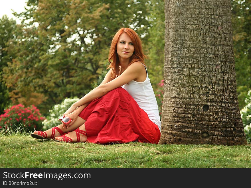 Beautiful young woman relaxing in park. Beautiful young woman relaxing in park