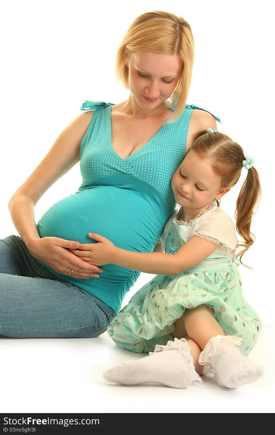 Cute girl embracing her pregnant mother