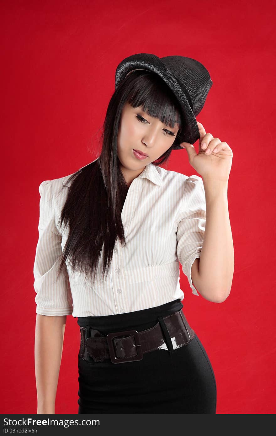 Young mixed race woman looking down. She is wearing a hat and is tilting her head slightly. Young mixed race woman looking down. She is wearing a hat and is tilting her head slightly.