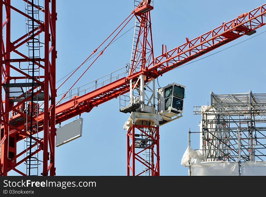 Cranes on a construction site, blue sky in the background