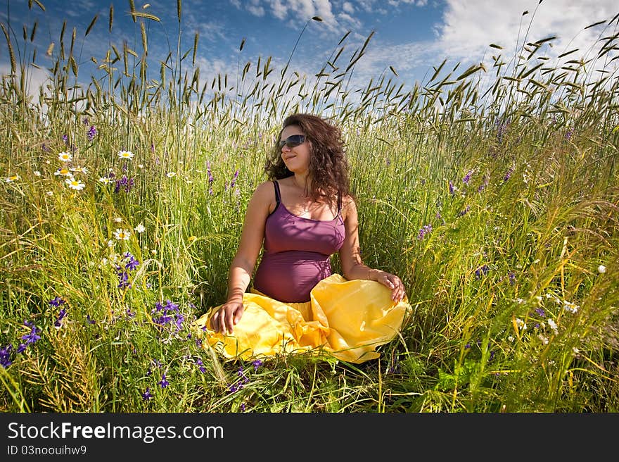 Pregnant woman on green grass field under blue sky