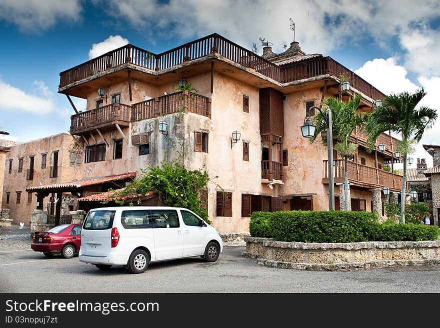 Old style Dominican eating house and hotel with green trees under blue sky