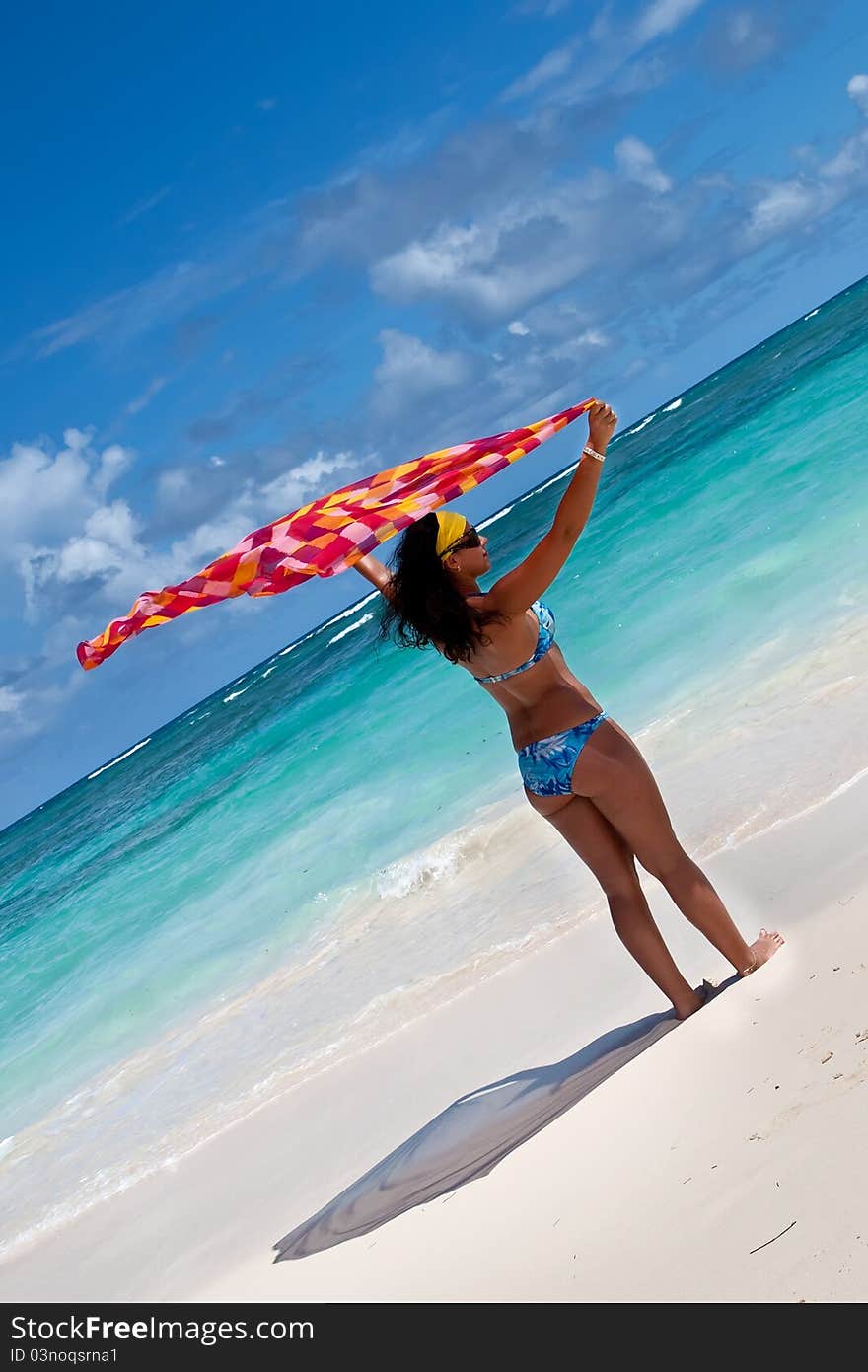 Tanned young europen women with red and orange pareo on white sand beach in summer. Tanned young europen women with red and orange pareo on white sand beach in summer