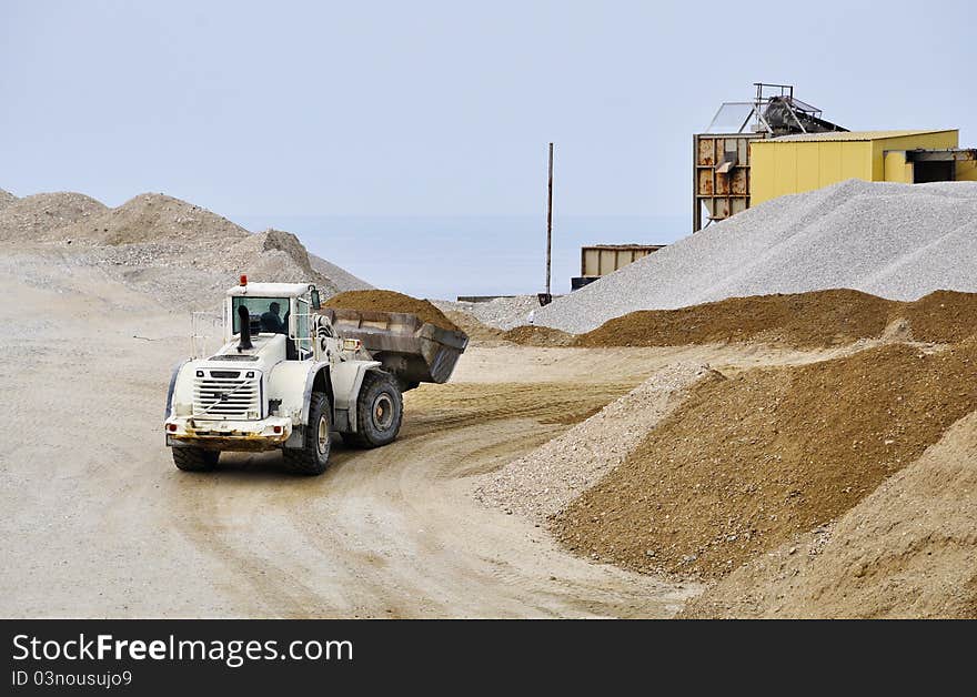 A white bulldozer moving gravel. A white bulldozer moving gravel