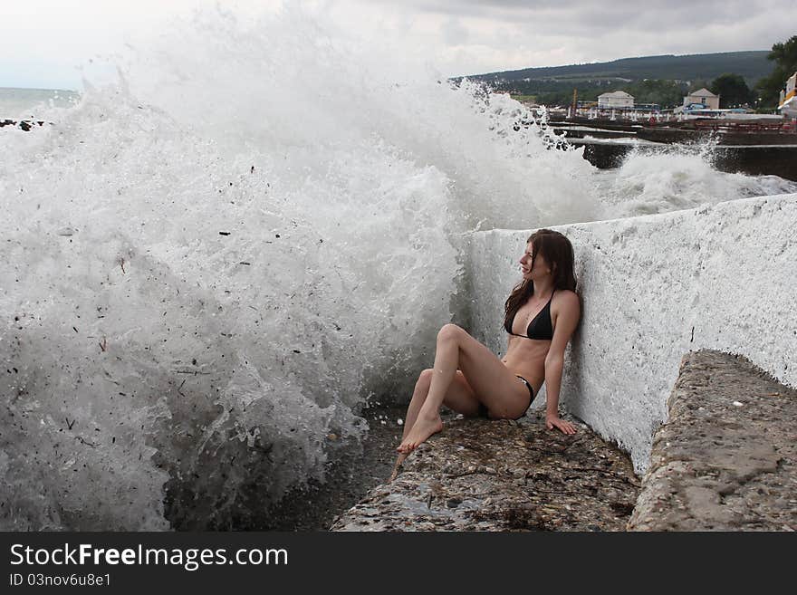 The beautiful and gentle girl against a raging sea storm.