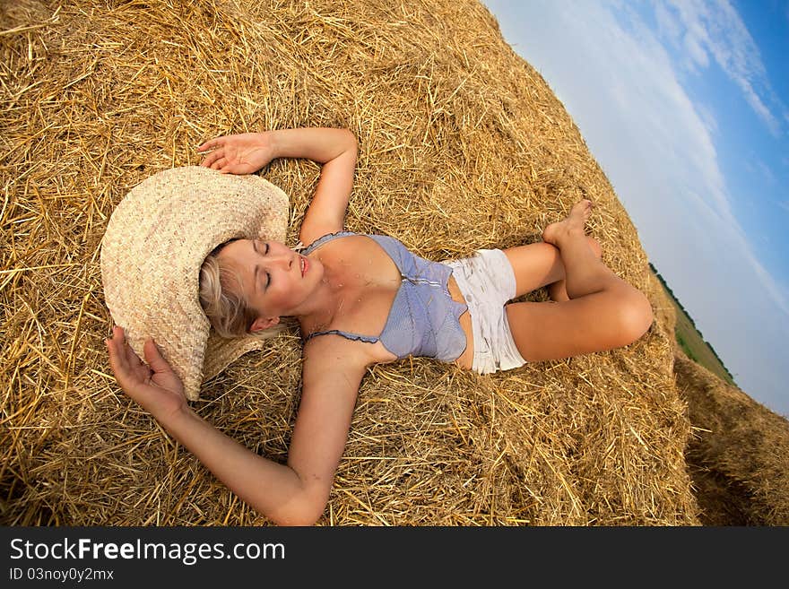 Woman relaxing in hay stack