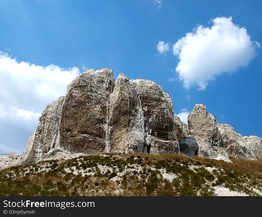 Photo of cretaceous rocky formation against the blue sky with clouds