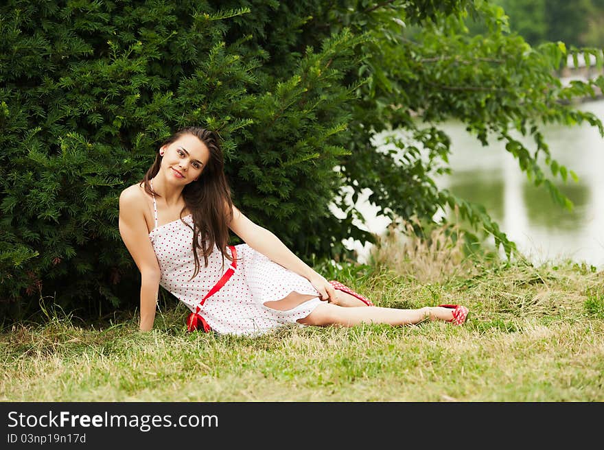 Beautiful attractive woman sitting on a grass