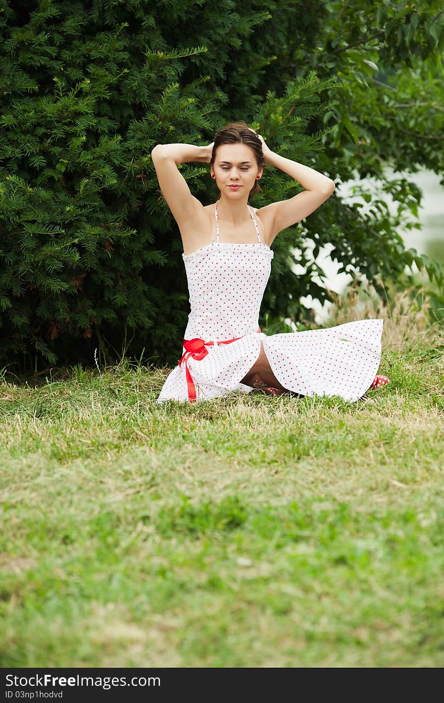 Beautiful young woman on field in a white dress